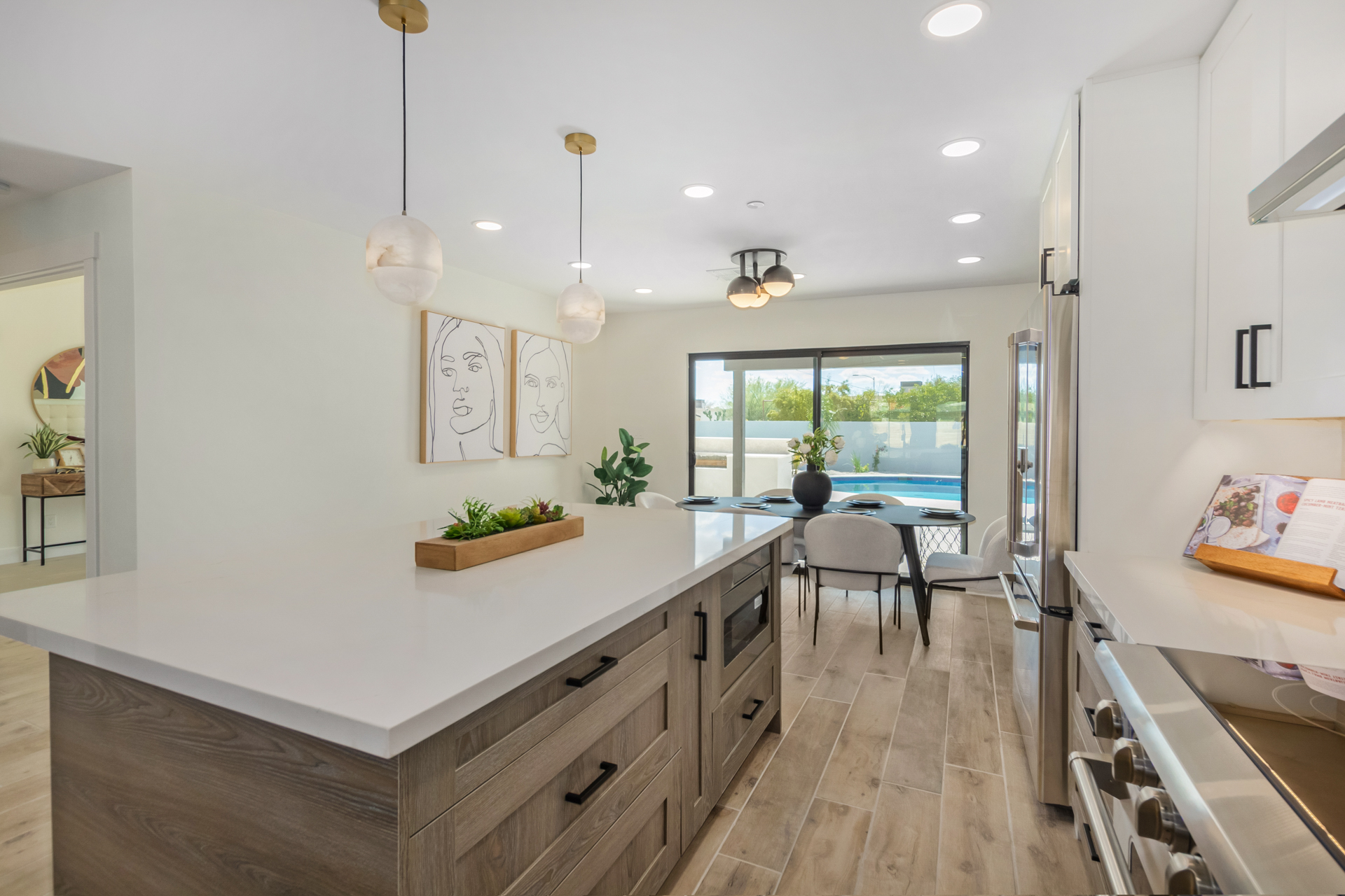 Completed Phoenix kitchen remodel with a large island, white cabinetry, and pool view